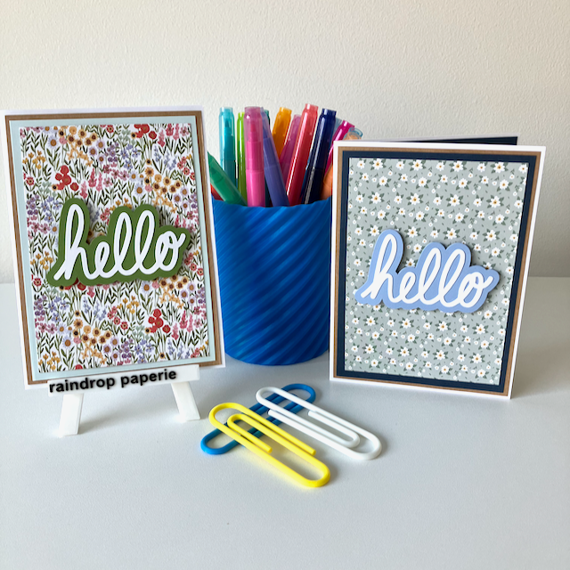 A set of handmade greeting cards with 'Hello' text, accompanied by floral designs, displayed on a white surface.