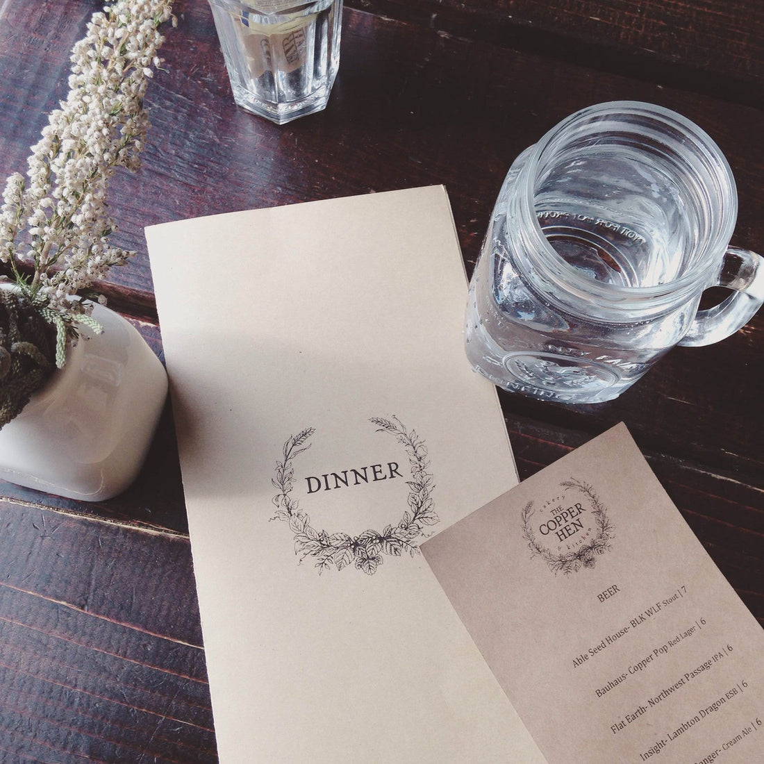 Restaurant table with menues, glasses and flowers. 