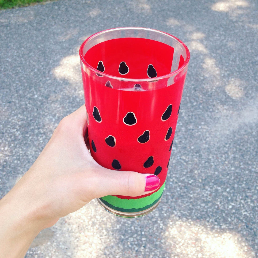 Hand holding a watermelon pattern cup.