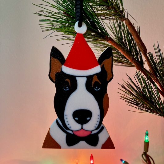 An English Bull Terrier with a red Santa hat and a black bow tie