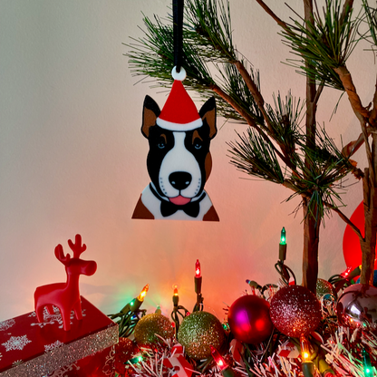 An English Bull Terrier with a red Santa hat and a black bow tie