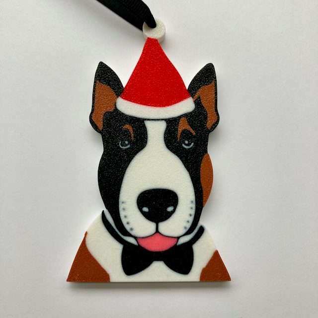 An English Bull Terrier with a red Santa hat and a black bow tie