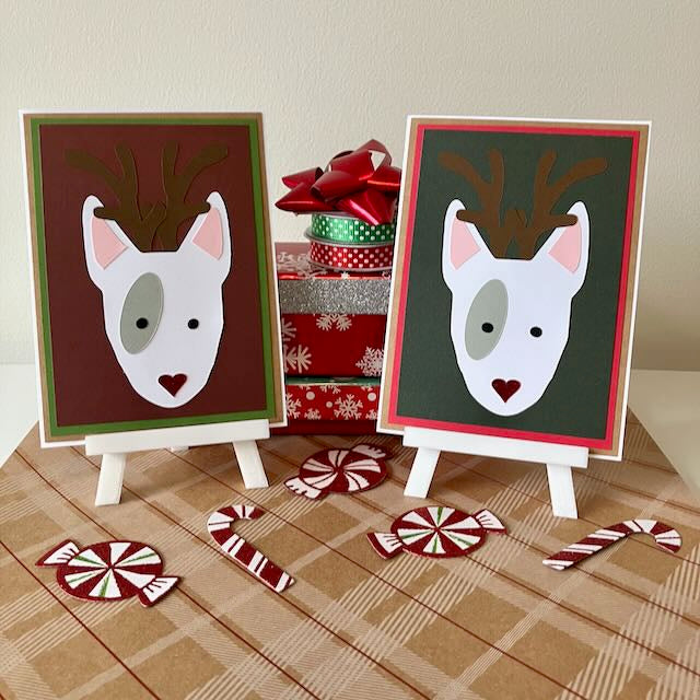 Two Christmas-themed cards with reindeer faces on stands, surrounded by candy canes and a gift box.