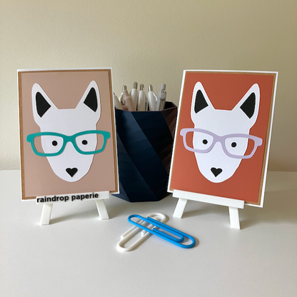 Two handmade greeting cards with English Bull Terrier faces wearing glasses. 