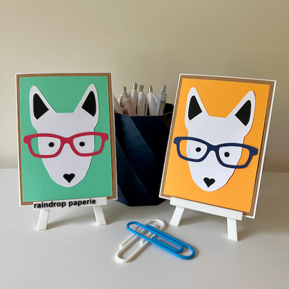 Two handmade greeting cards with English Bull Terrier faces wearing glasses. 