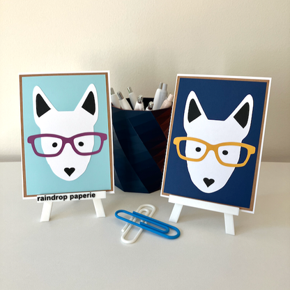 Two handmade greeting cards with English Bull Terrier faces wearing glasses. 