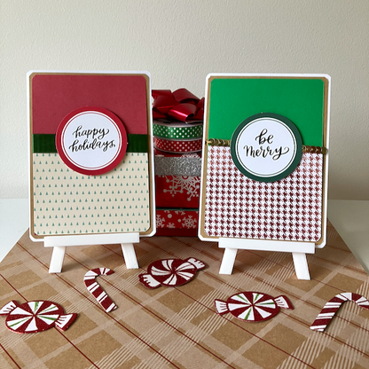 Two decorative greeting cards with festive designs on a plaid surface with candy-themed decor.
