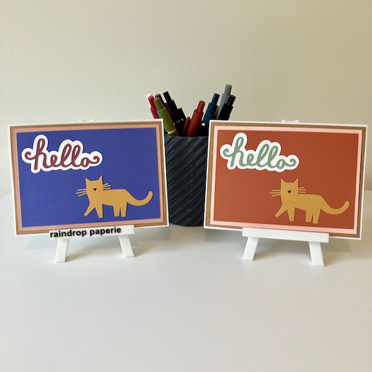 Two handmade greeting cards with cats and 'hello' on the front.