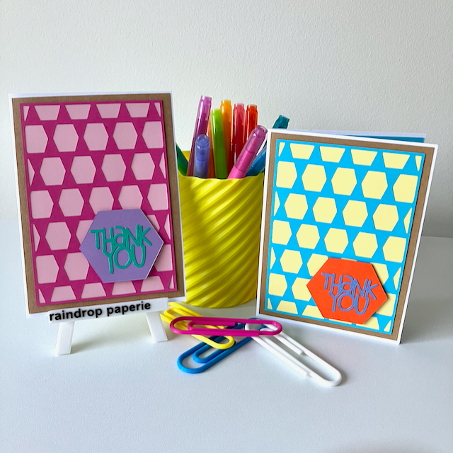 Two handmade greeting cards with geometric patterns and 'Thank You' text  displayed with stationery items.