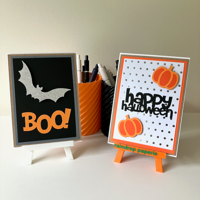 Two handmade Halloween greeting cards with pumpkins and a bat.