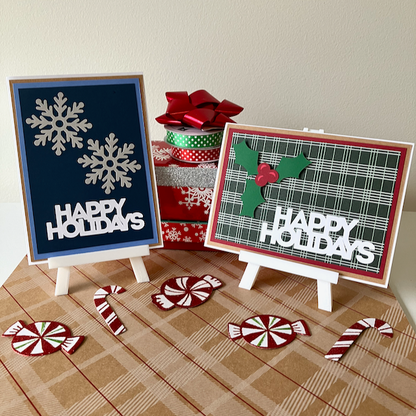 Two 'Happy Holidays' signs on small easels with gift wrap and candy decorations.