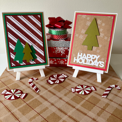 Two Christmas-themed cards on small easels with decorative ribbons and candy canes on a plaid surface.