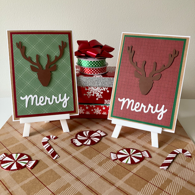 Two Christmas-themed greeting cards with reindeer designs on a plaid surface with candy decorations.