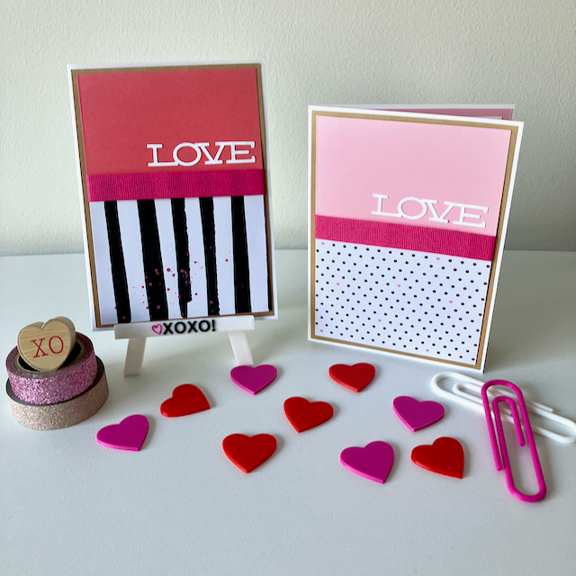 Two handmade greeting cards that say 'Love' displayed on a table with decorative hearts. 