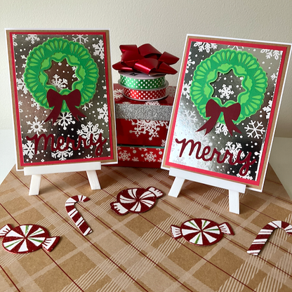 Two Christmas-themed greeting cards with wreaths and 'Merry' text, surrounded by decorative items on a patterned surface.