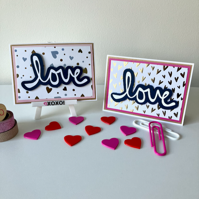 Two handmade greeting cards with 'LOVE' text displayed on a table with decorative elements.