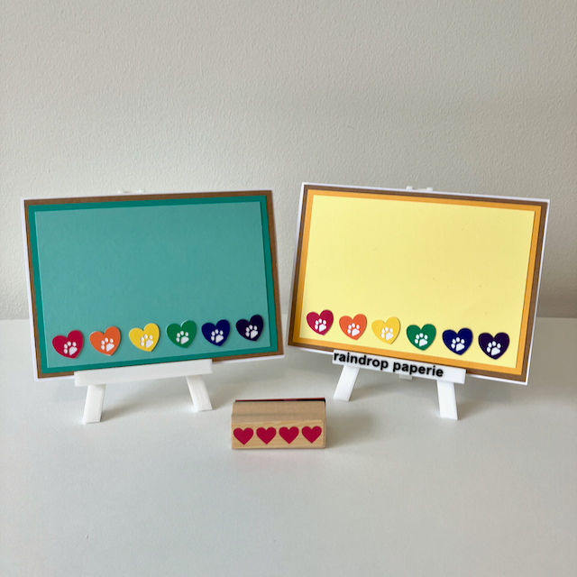 Two handmade greeting cards with hearts and paw prints in rainbow colors. 